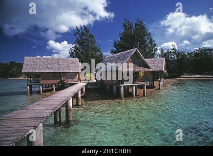 Vanuatu. Efate. Port Vila. Überwasser strohgedeckte Bungalowhütten am Wasser. Stockfoto