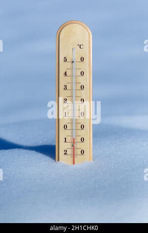 Ein Thermometer im blauen Schnee zeigt eine Temperatur von -7 Grad Celsius Stockfoto