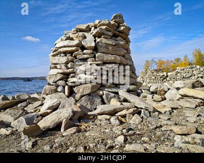 Ein Turm aus Steinen am Ufer des Sees. Touristenattraktion. Stockfoto