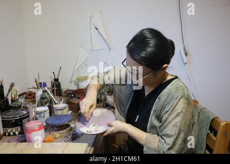 Nanchang, Chinas Provinz Jiangxi. Oktober 2021. Die japanische Künstlerin Ayao Takayanagi arbeitet in Jingdezhen, ostchinesischer Provinz Jiangxi, 10. Oktober 2021. Quelle: Cheng Di/Xinhua/Alamy Live News Stockfoto