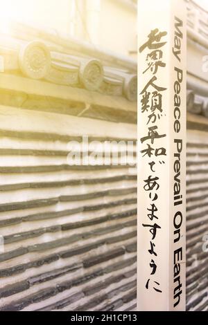 Der berühmte Satz „Möge der Frieden auf Erden herrschen“ von Goi Masahisa, dem Schöpfer der Schule von Byakko Shinkokai, wurde auf den von WPPS gepflanzten Pol eines Friedenspol-Projekts geschrieben Stockfoto