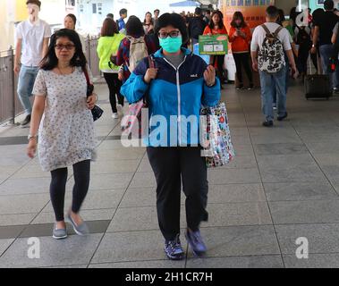 HONGKONG, CHINA - 29. APRIL 2017: Asiaten mit einer Frau, die eine Operationsmaske zum Virenschutz trägt, alle in der Fußgängerbrücke, die die wa ist Stockfoto