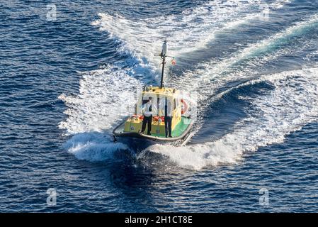 Kingstown, Saint Vincent und die Grenadinen - 19. Dezember 2018: Hafenmeister-Pilotboot mit Crew an Deck schwimmt zum Kreuzfahrtschiff in Port of Kingstown Stockfoto