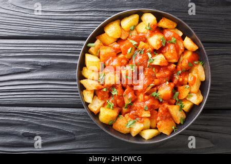 Patatas Bravas Rezept Bratkartoffeln mit Bravas-Sauce in der Nähe auf dem Teller auf dem Tisch. Horizontale Draufsicht von oben Stockfoto