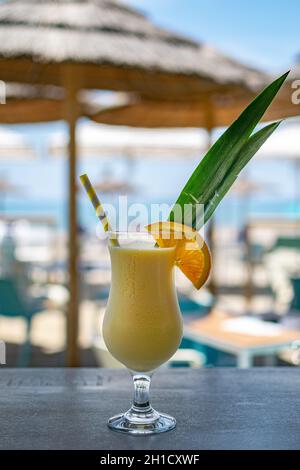 Ein Bild eines frisch zubereiteten tropischen piña Colada-Cocktails mit einem Barhintergrund am Strand Stockfoto