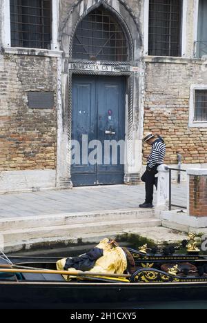 VENEDIG, ITALIEN - 13. Okt 2013: Alleinerziehende männliche Gondoliere, die vor einem typisch venezianischen Haus, Italien, steht Stockfoto