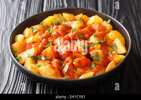 Patatas Bravas oder Kartoffeln in Bravas-Sauce sind ein klassisches spanisches Tapas-Gericht aus nächster Nähe auf dem Teller auf dem Tisch. Horizontal Stockfoto