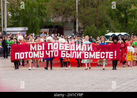 Anapa, Russland - 9. Mai 2019: Jugendliche in Volkstrachten tragen ein Schild "wir haben gewonnen, weil wir zusammen waren" bei der Siegestagsparade am 9. Mai in Anapa Stockfoto