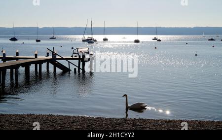 Eine malerische Aussicht auf Segelboote in der Sonne an der Bucht am Ammersee in Deutschland Stockfoto