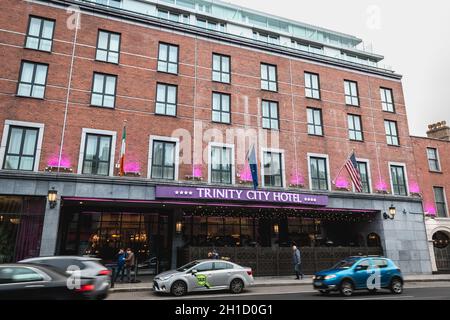 Dublin, Irland - 11. Februar 2019: Menschen und Autos, die an einem Wintertag an der Fassade des luxuriösen Trinity City Hotels in der Innenstadt vorbeifahren Stockfoto