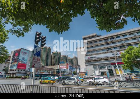 Yichang, China - August 2019: Eine Reihe von Autos, die an einem heißen Sommertag in der Stadt Yichang in der Provinz Hubei auf grünes Licht auf einer belebten Kreuzung warten Stockfoto