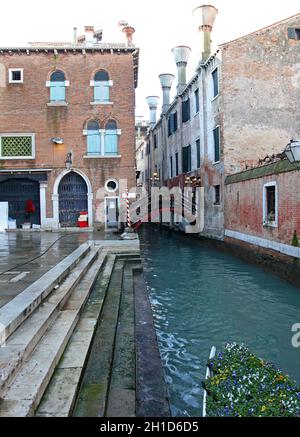 Venedig, Italien - 19. Dezember 2012: Steinstufen und Holzbrücke über den kleinen Kanal in Venedig, Italien. Stockfoto