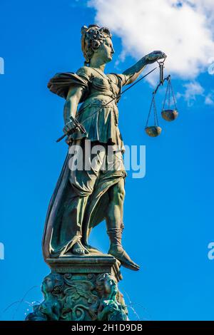 Schöne Nahaufnahme der berühmten Bronzeskulptur von Justitia am Brunnen der Gerechtigkeit in Frankfurt. Die Göttin der Gerechtigkeit hält eine... Stockfoto