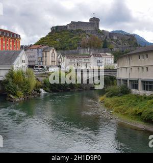 Lourdes, Frankreich - 9 Okt, 2021: Blick entlang des Flusses Ousse in Richtung Schloss Lourdes und Pyrenäenmuseum Stockfoto