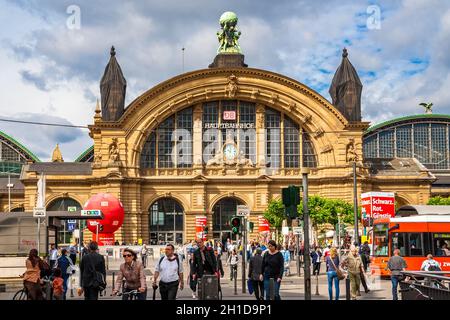 Menschen überqueren die Straße vor dem Frankfurter Hauptbahnhof mit dem schönen östlichen façade. Über einer Uhr kann das Wort Hauptbahnhof... Stockfoto