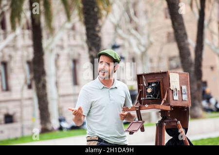 BARCELONA - MÄRZ 2018: Junger männlicher Fotograf, der mit einer alten Holzkamera am Triumphbogen in Barcelona fotografiert Stockfoto