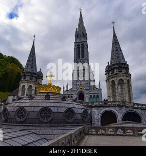 Lourdes, Frankreich - 9 Oct 2021: Goldvergoldetes Kreuz auf der Kuppel der Basilika unserer Lieben Frau vom Rosenkranz in Lourdes Stockfoto