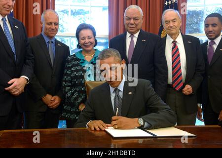 Der US-Präsident Barack Obama unterzeichnet mit dem Gründungsvorsitzenden der Promise Alliance und dem ehemaligen US-Außenminister Colin Powell (3R), der derzeitigen Vorstandsvorsitzenden Alma Powell (3L), Führern und Teilnehmern, während einer Zeremonie im Oval Office des Weißen Hauses in Washington, DC, die Erklärung des amerikanischen Promise Summit, USA 22. September 2014. Präsident Obama wird der siebte Präsident in Folge sein, der die Erklärung unterzeichnet, die die Amerikaner auffordert, der Jugend Amerikas dabei zu helfen, ihr volles Potenzial auszuschöpfen. Kredit: Shawn Thew/Pool über CNP Stockfoto