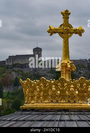 Lourdes, Frankreich - 9 Oct 2021: Goldvergoldetes Kreuz auf der Kuppel der Basilika unserer Lieben Frau vom Rosenkranz in Lourdes Stockfoto