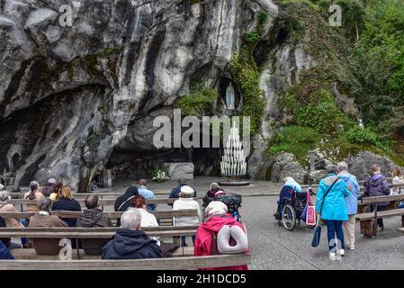 Lourdes, Frankreich - 9. Oktober 2021: Katholische Pilger nehmen an einem Gottesdienst in der Grotte Massabielle in der Rosenkranzbasilika von Lourdes Teil Stockfoto