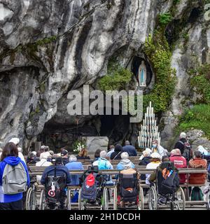 Lourdes, Frankreich - 9. Oktober 2021: Katholische Pilger nehmen an einem Gottesdienst in der Grotte Massabielle in der Rosenkranzbasilika von Lourdes Teil Stockfoto