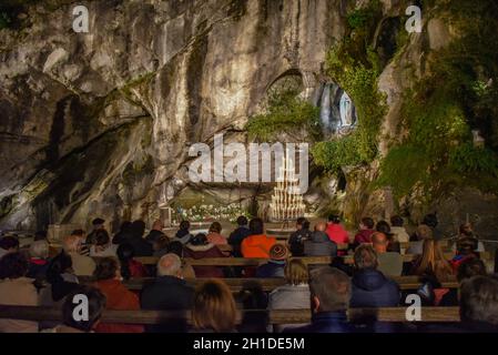 Lourdes, Frankreich - 9. Oktober 2021: Abendgottesdienst in der Grotte Massabielle, Rosenkranzbasilika, Lourdes Stockfoto