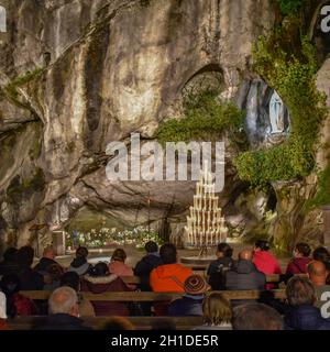 Lourdes, Frankreich - 9. Oktober 2021: Abendgottesdienst in der Grotte Massabielle, Rosenkranzbasilika, Lourdes Stockfoto