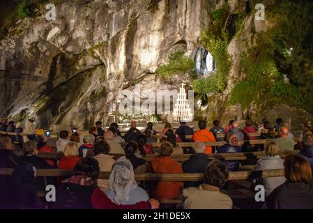 Lourdes, Frankreich - 9. Oktober 2021: Abendgottesdienst in der Grotte Massabielle, Rosenkranzbasilika, Lourdes Stockfoto