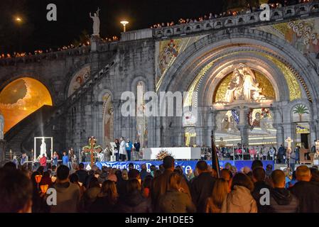 Lourdes, Frankreich - 9. Oktober 2021: Pilger nehmen an der Marienfackelprozession in der Rosenkranzbasilika in Lourdes Teil Stockfoto