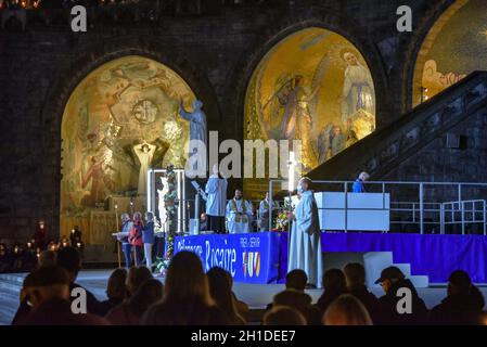 Lourdes, Frankreich - 9. Oktober 2021: Pilger nehmen an der Marienfackelprozession in der Rosenkranzbasilika in Lourdes Teil Stockfoto