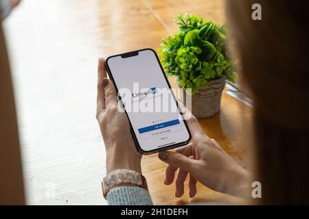 CHIANG MAI, THAILAND, OCT 17, 2021 : Eine Frau hält Apple iPhone pro max mit LinkedIn-Anwendung auf dem Bildschirm.LinkedIn ist eine Foto-Sharing-App für Stockfoto