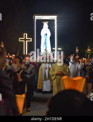 Lourdes, Frankreich - 9. Oktober 2021: Während der Marian Facklight Prozession in der Rosenkranzbasilika i wird eine Statue der Jungfrau Maria in die Menge getragen Stockfoto