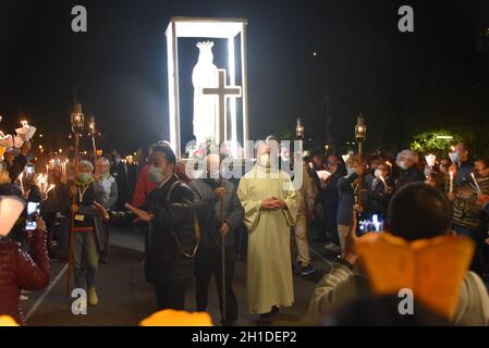 Lourdes, Frankreich - 9. Oktober 2021: Während der Marian Facklight Prozession in der Rosenkranzbasilika i wird eine Statue der Jungfrau Maria in die Menge getragen Stockfoto