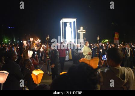 Lourdes, Frankreich - 9. Oktober 2021: Während der Marian Facklight Prozession in der Rosenkranzbasilika i wird eine Statue der Jungfrau Maria in die Menge getragen Stockfoto