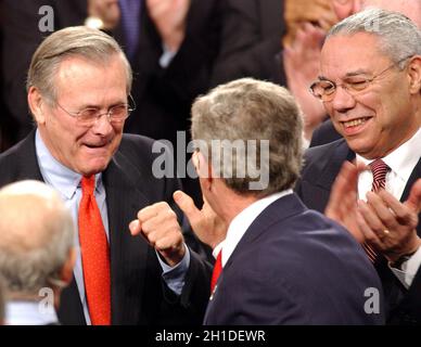 Washington, Vereinigte Staaten. Januar 2004. US-Präsident George W. Bush erhält einige ermutigende Worte von US-Verteidigungsminister Donald Rumsfeld, links, wie US-Außenminister Colin Powell, rechts, anschaut, als er am 20. Januar 2004 in der Kammer des Repräsentantenhauses der Vereinigten Staaten in Washington, DC, eintrifft. Kredit: Ron Sachs/CNP/dpa/Alamy Live Nachrichten Stockfoto