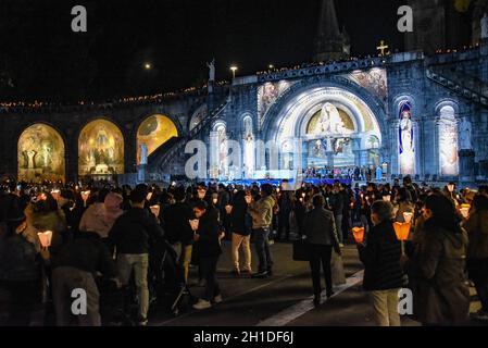 Lourdes, Frankreich - 9. Oktober 2021: Pilger nehmen an der Marienfackelprozession in der Rosenkranzbasilika in Lourdes Teil Stockfoto