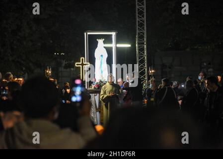 Lourdes, Frankreich - 9. Oktober 2021: Während der Marian Facklight Prozession in der Rosenkranzbasilika i wird eine Statue der Jungfrau Maria in die Menge getragen Stockfoto