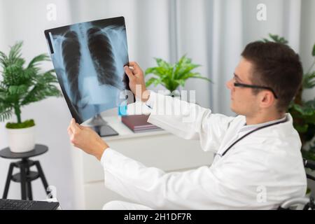 In einem Krankenhaus überprüft ein pulmonologischer Arzt die Röntgenaufnahme der Lunge eines Patienten. Stockfoto