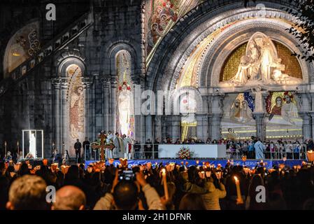 Lourdes, Frankreich - 9. Oktober 2021: Pilger nehmen an der Marienfackelprozession in der Rosenkranzbasilika in Lourdes Teil Stockfoto