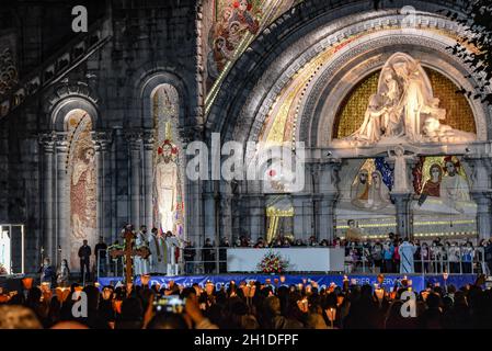 Lourdes, Frankreich - 9. Oktober 2021: Pilger nehmen an der Marienfackelprozession in der Rosenkranzbasilika in Lourdes Teil Stockfoto