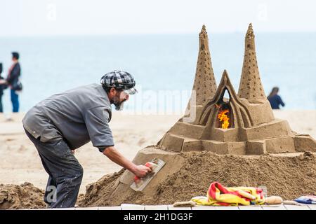 BARCELONA - MÄRZ 2018: Sandbildhauer am Strand La Barceloneta in Barcelona, Spanien Stockfoto