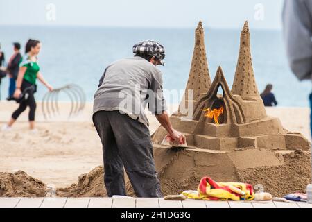 BARCELONA - MÄRZ 2018: Sandbildhauer am Strand La Barceloneta in Barcelona, Spanien Stockfoto