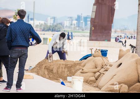 BARCELONA - MÄRZ 2018: Sandbildhauer am Strand La Barceloneta in Barcelona, Spanien Stockfoto