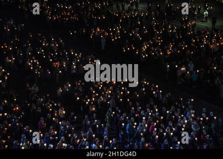 Lourdes, Frankreich - 9. Oktober 2021: Pilger nehmen an der Marienfackelprozession in der Rosenkranzbasilika in Lourdes Teil Stockfoto