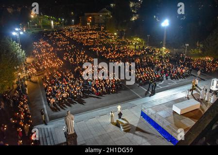 Lourdes, Frankreich - 9. Oktober 2021: Pilger nehmen an der Marienfackelprozession in der Rosenkranzbasilika in Lourdes Teil Stockfoto