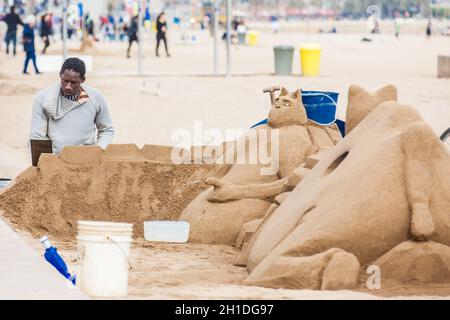 BARCELONA - MÄRZ 2018: Sandbildhauer am Strand La Barceloneta in Barcelona, Spanien Stockfoto