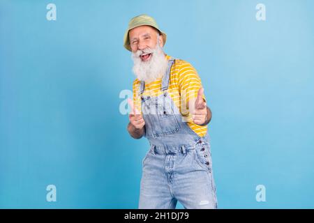 Foto von aufgeregt gealterten Mann glücklich positives Lächeln zeigen Finger, die Sie wählen isoliert über blauen Hintergrund Stockfoto