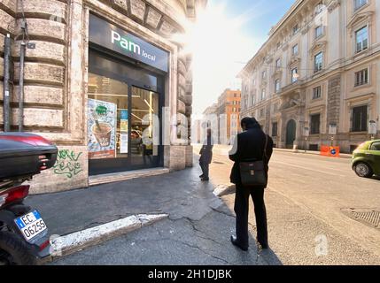 Rom, Italien, 8. April 2020: Menschen, die vor einem Supermarkt Schlange stehen, tragen Masken und halten während des Coronavirus COVID-19 p den sozialen Sicherheitsabstand ein Stockfoto