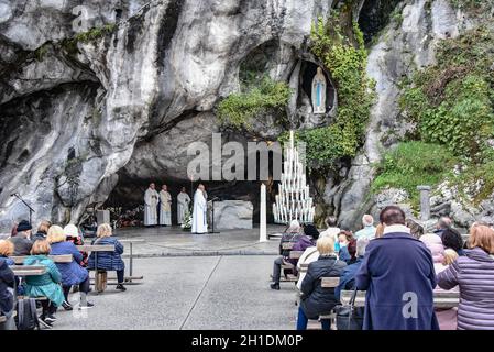 Lourdes, Frankreich - 9. Oktober 2021: Katholische Pilger nehmen an einem Gottesdienst in der Grotte Massabielle in der Rosenkranzbasilika von Lourdes Teil Stockfoto