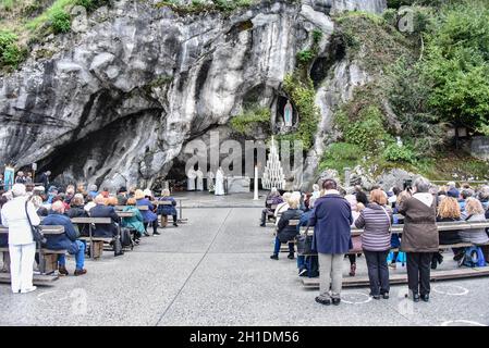 Lourdes, Frankreich - 9. Oktober 2021: Katholische Pilger nehmen an einem Gottesdienst in der Grotte Massabielle in der Rosenkranzbasilika von Lourdes Teil Stockfoto